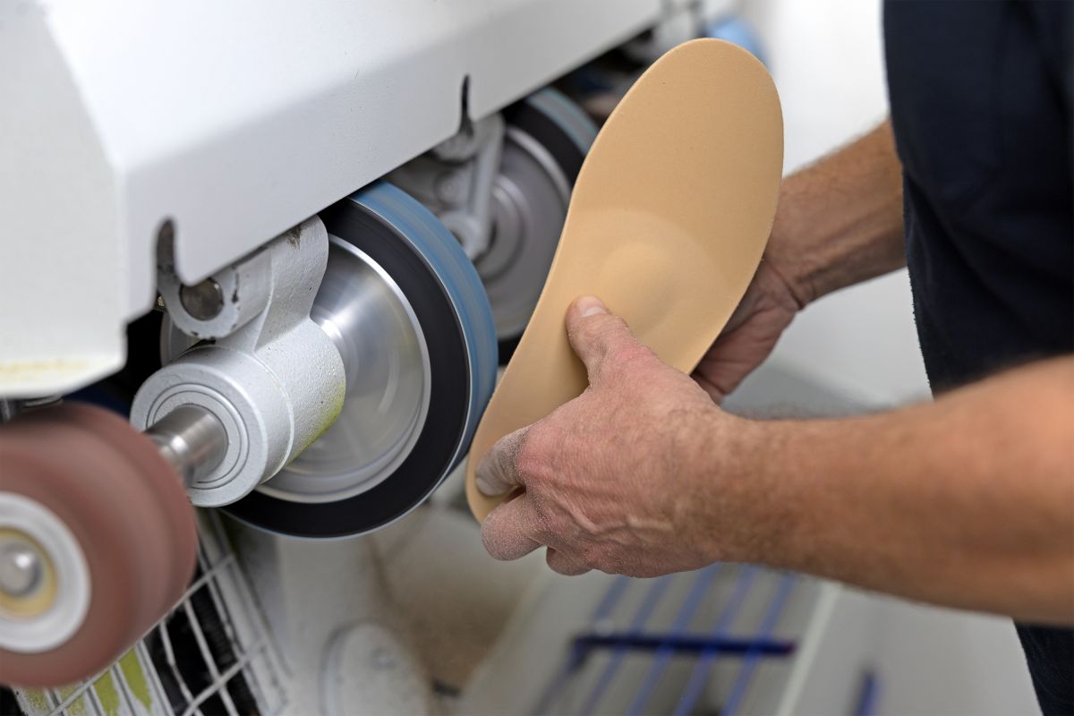 Die Kanten einer beigen Einlage werden abgeschliffen um eine saumere Kante zu erhalten