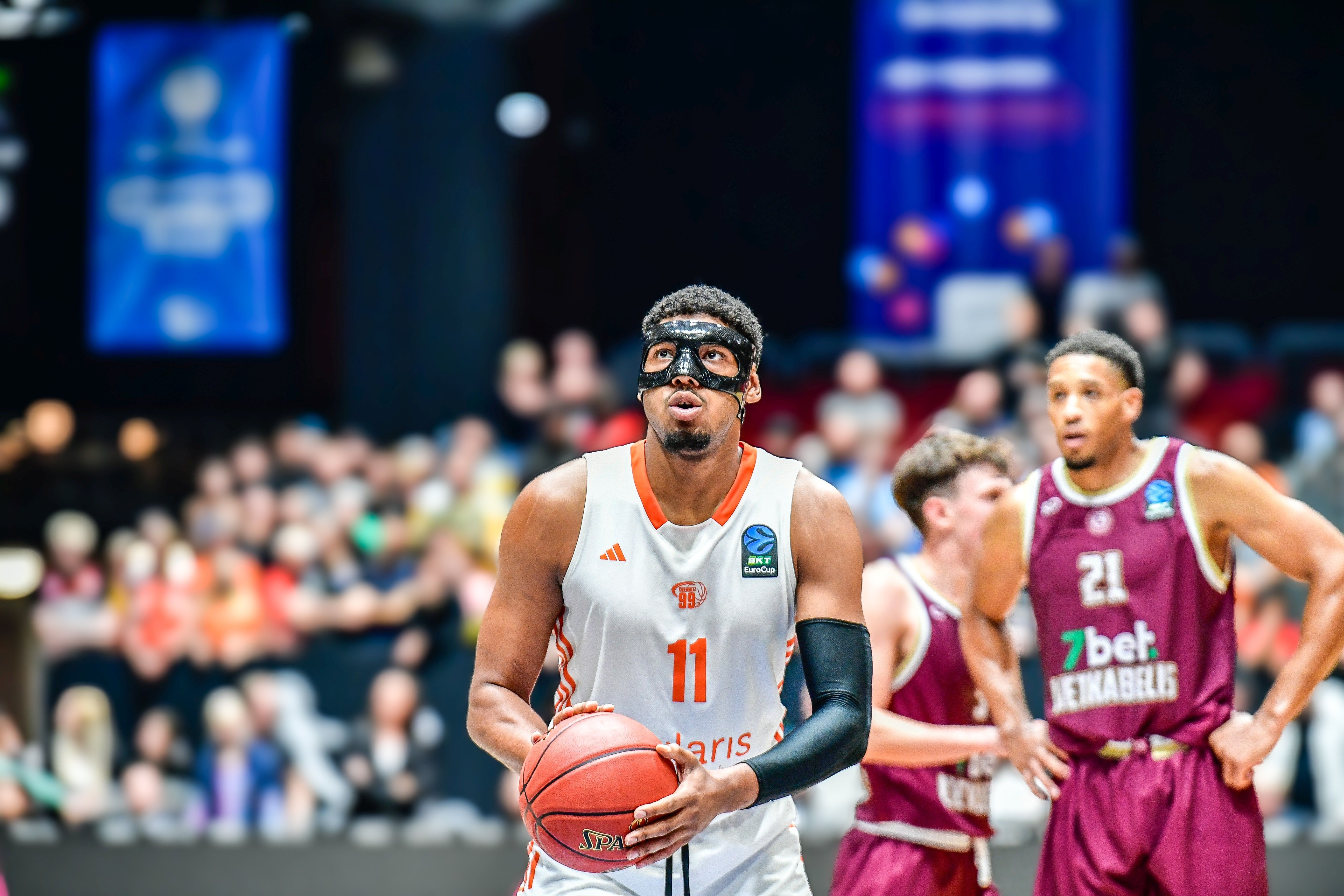 Basketballspieler trägt im Spiel eine schwarze Maske über Stirn und Nase zum Schutz